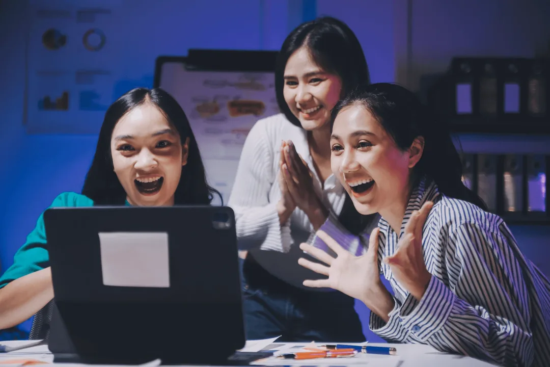 Tim sedang berdiskusi di depan laptop menggunakan hosting Clouden